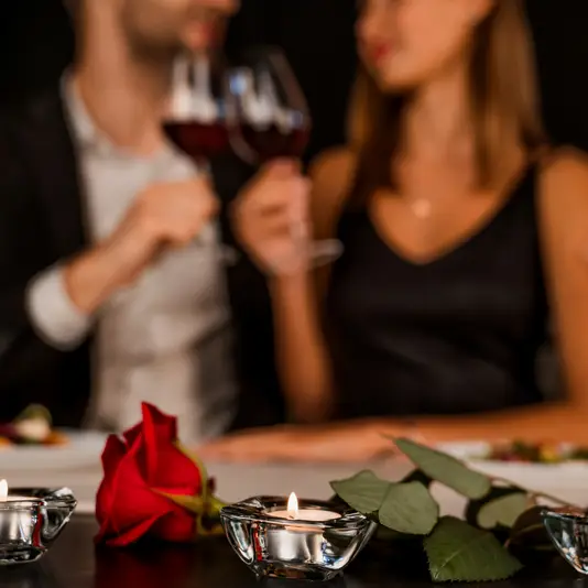 Romantic dinner date at night with focus on rose and candles